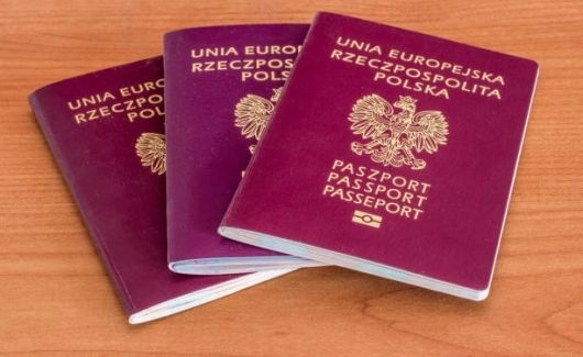 Na biurku leżą trzy paszporty